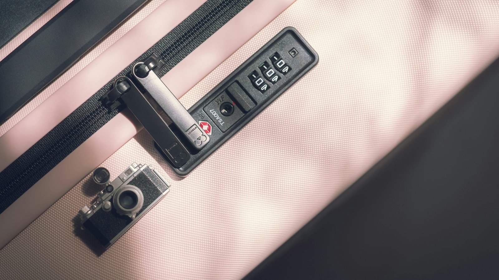 Reißverschluss an einem Koffer klemmt in Nahaufnahme bei neutralem Licht.